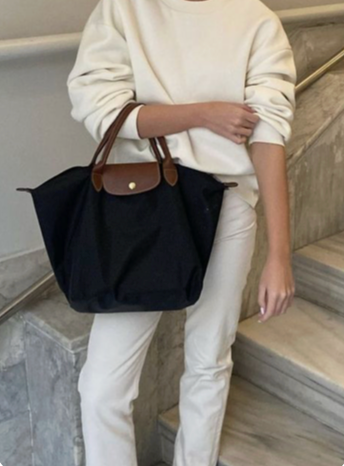 mujer llevando cartera de color negro