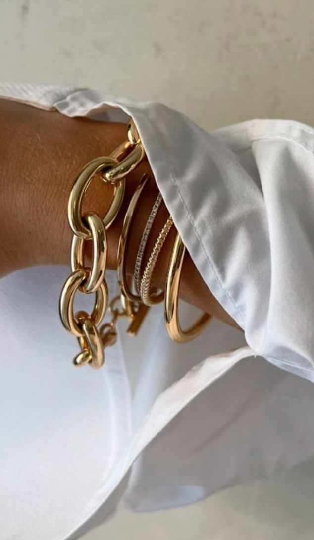 mujer portando varias pulseras y una camisa blanca