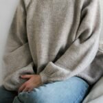 una persona portando un suéter en color gris